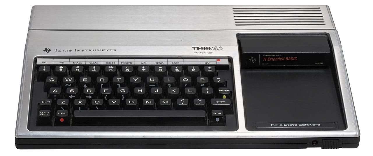 TI-99/4A personal computer, circa 1981. The device includes a full-sized keyboard with no number pad, and a slot to the right of the keyboard for cartridges (like game cartridges from the area) to be inserted.